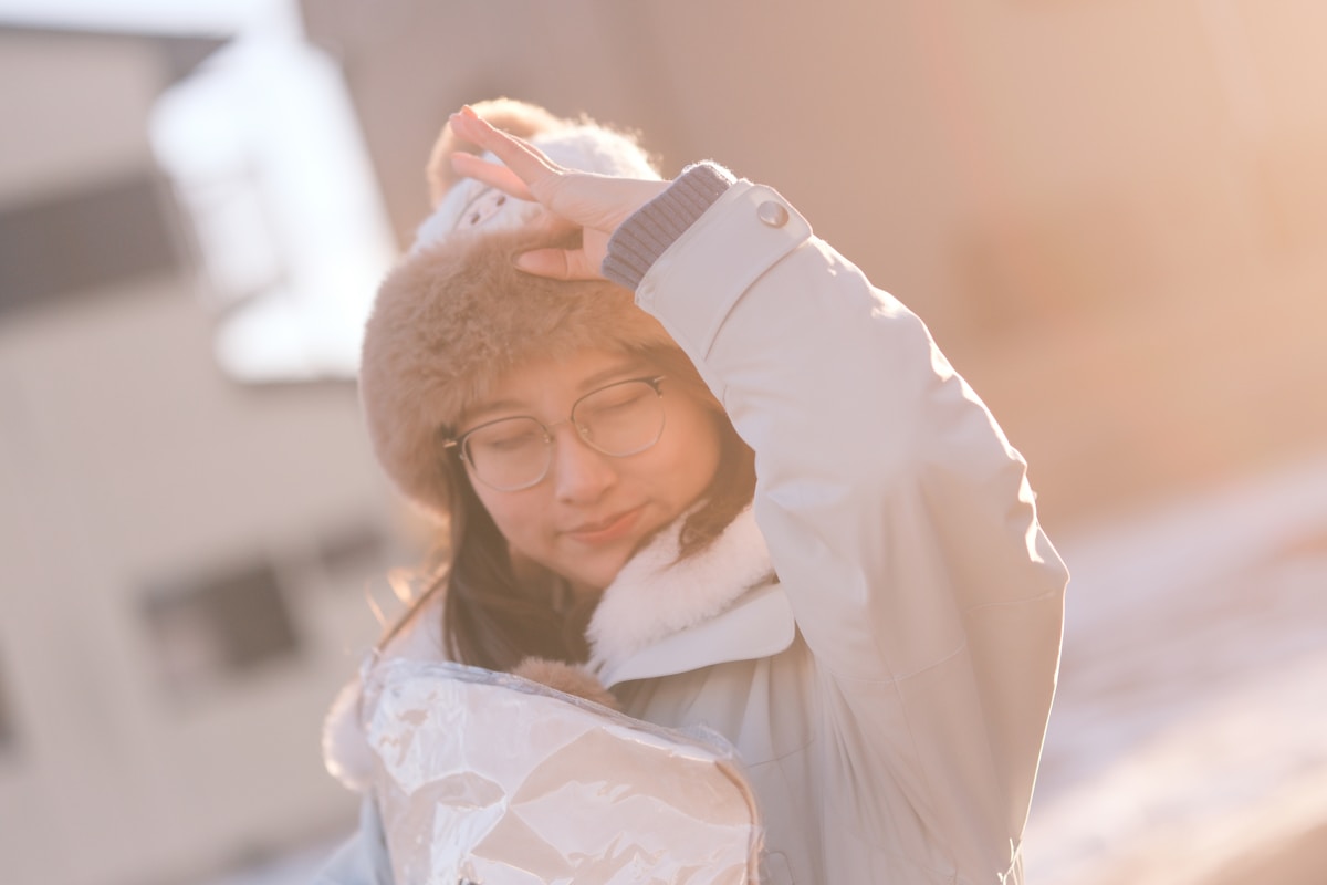 Woman in a hat shielding eyes from low sunlight.